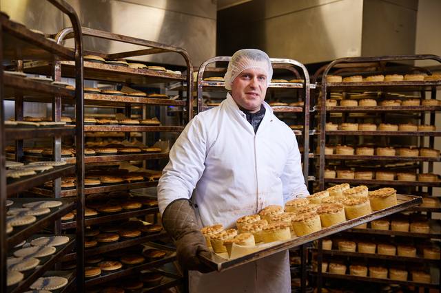 Een FreshCut-bakker met een volle plaat pies in de bakkerij